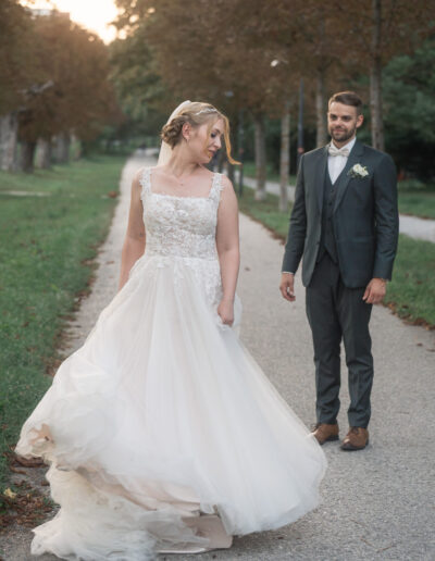Hochzeitsfoto, Braut präsentiert ihrem Bräutigam ihr Brautkleid im Park