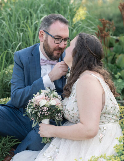 Hochzeitsfoto, Paar sitzt im gras und schaut sich verliebt an