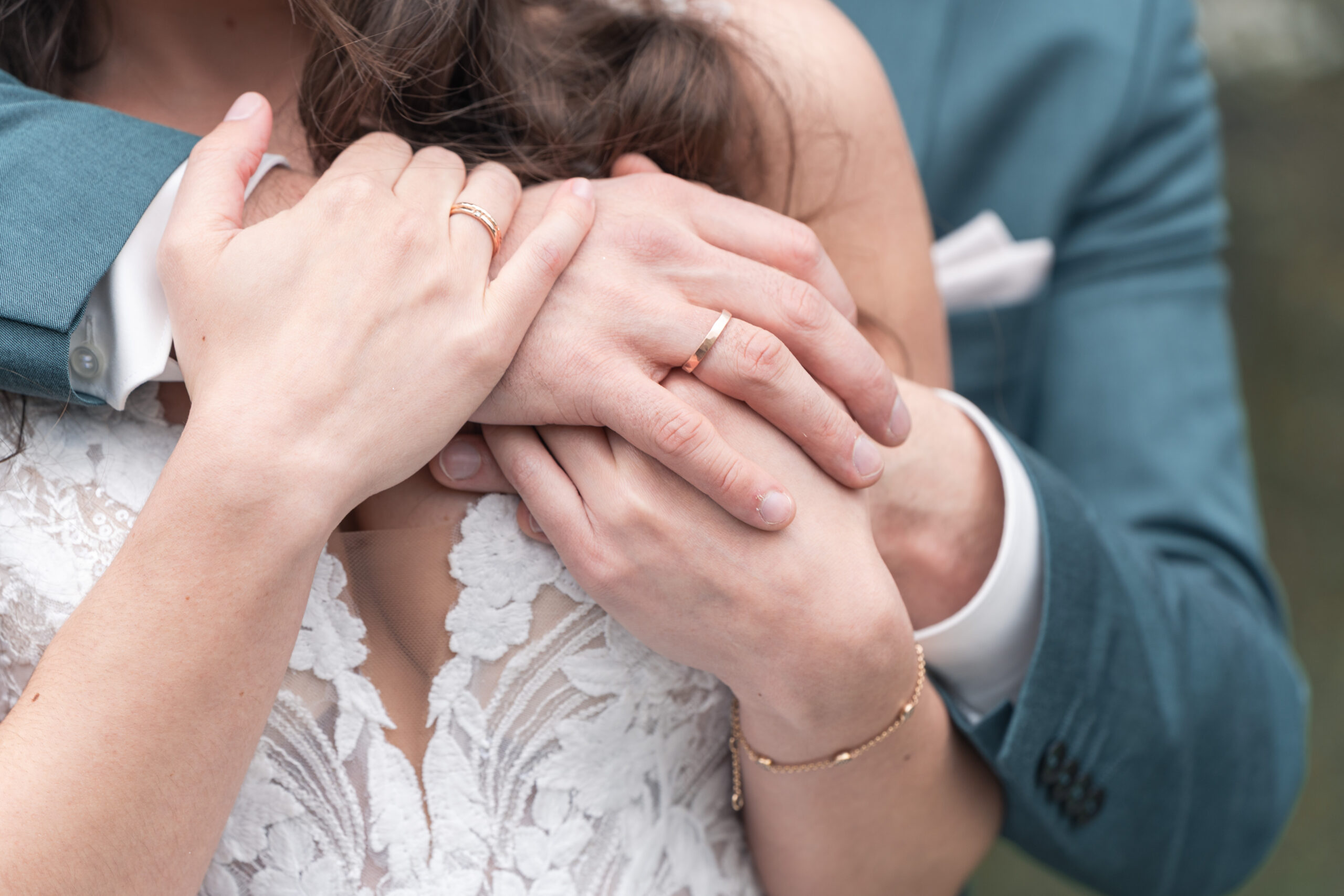 Hände, die einander halten, Eheringe sind gut sichtbar