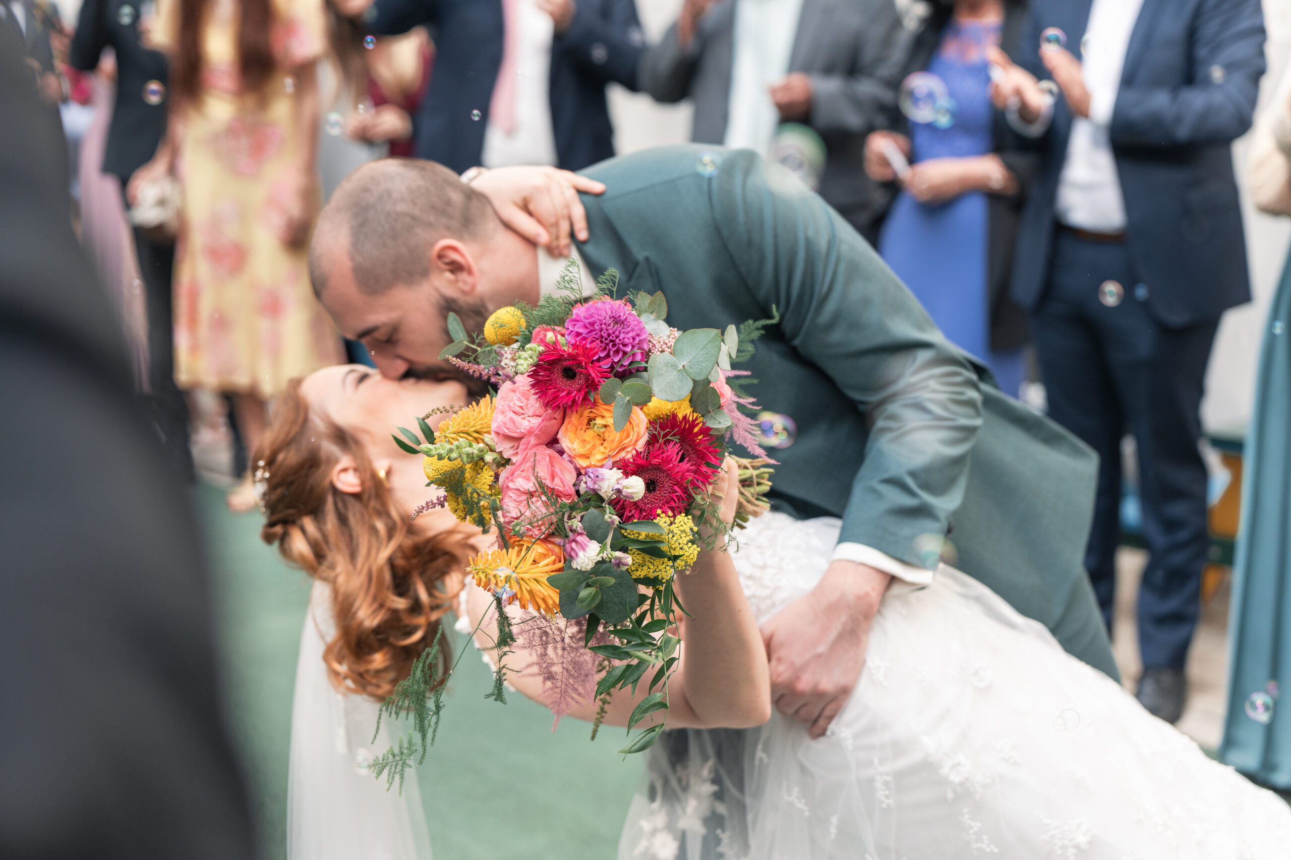 hochzeitsfoto, unscharf küssendes Paar, Fokus auf Brautstrauß, Muttergotteskirche